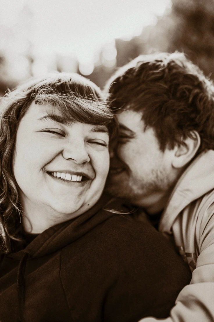 Candid sepia-toned portrait of a couple laughing together