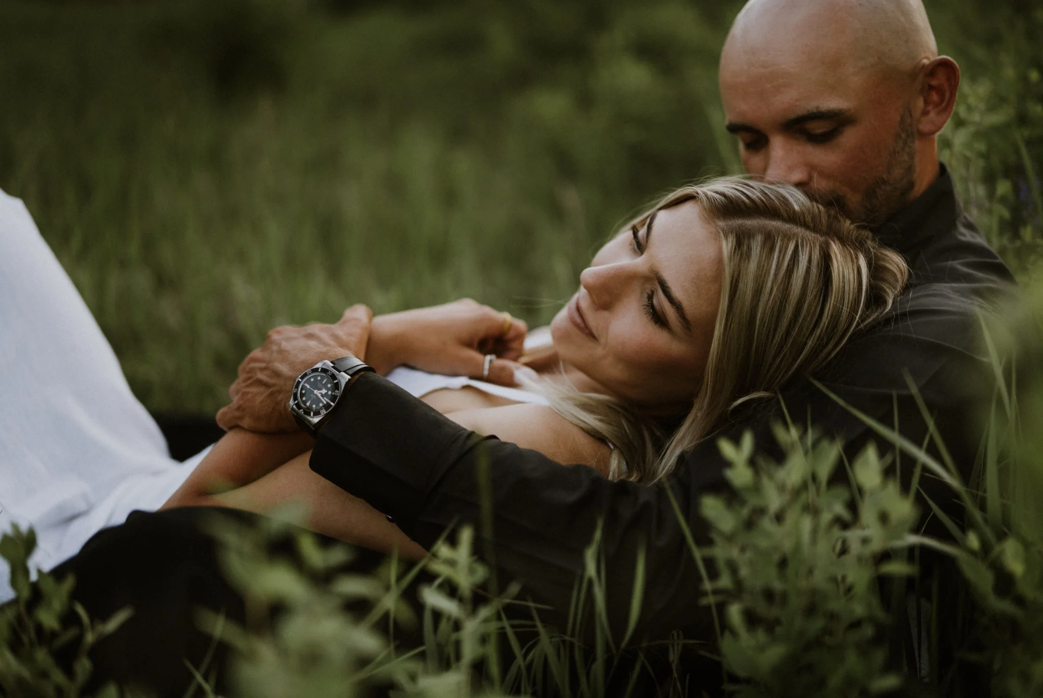 A couple resting together in a green meadow