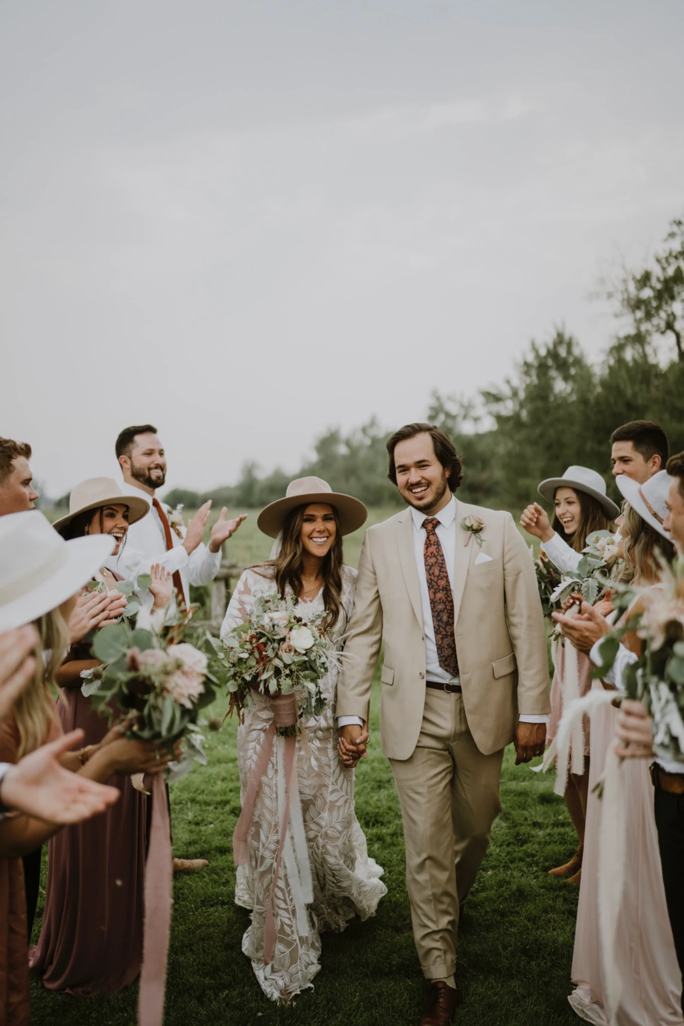 Newlywed couple walking through cheering family and friends