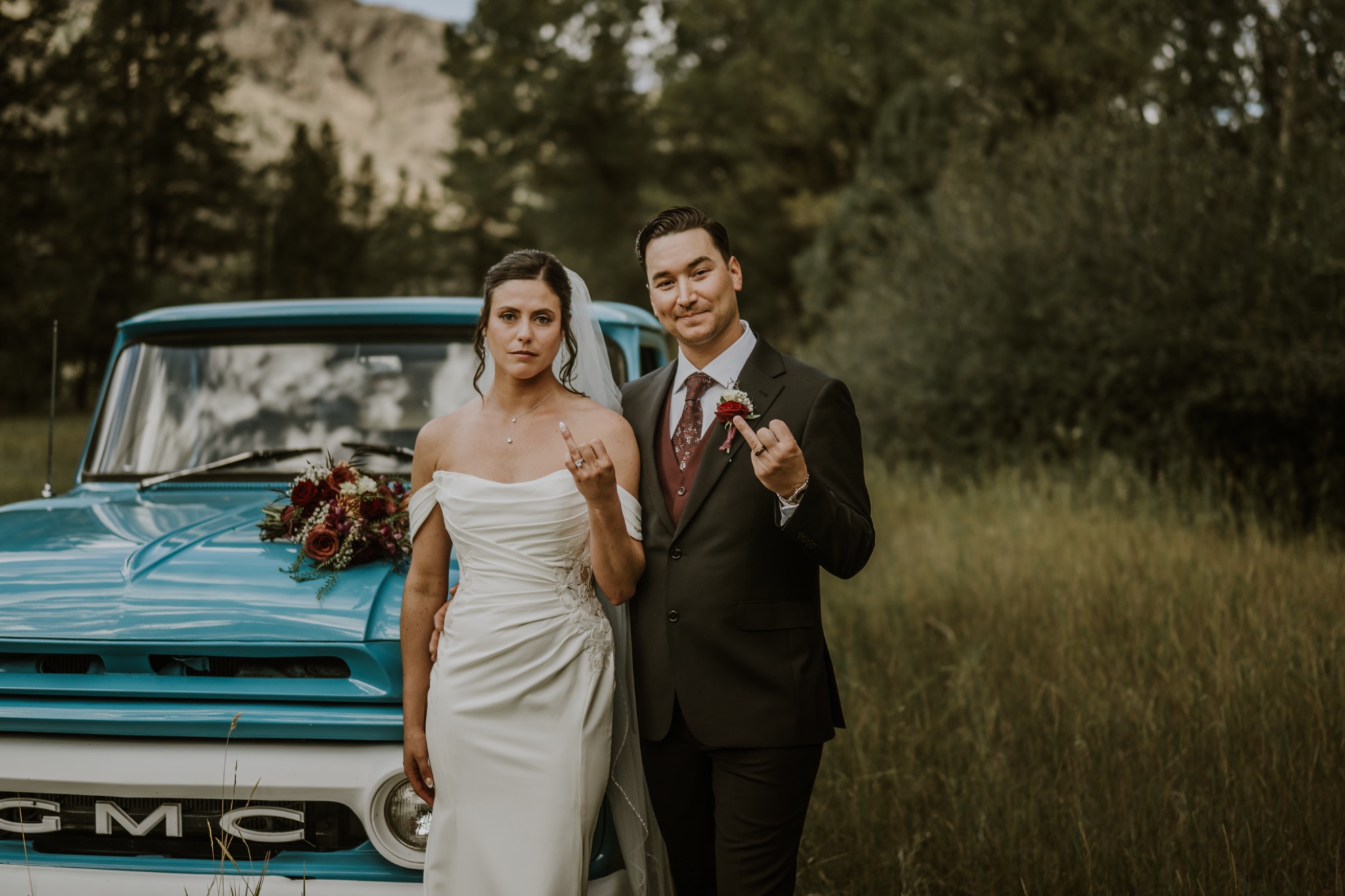 Bride and groom standing in front of a turquoise truck with playful portraits